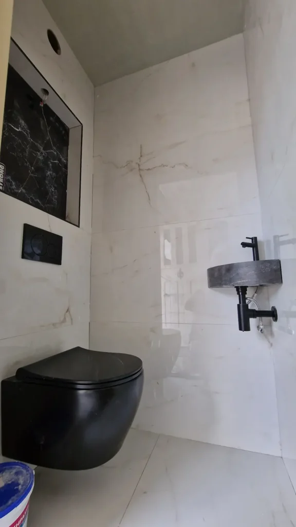 QA Renovatie: zwart hangtoilet en fonteintje in wit marmerlook