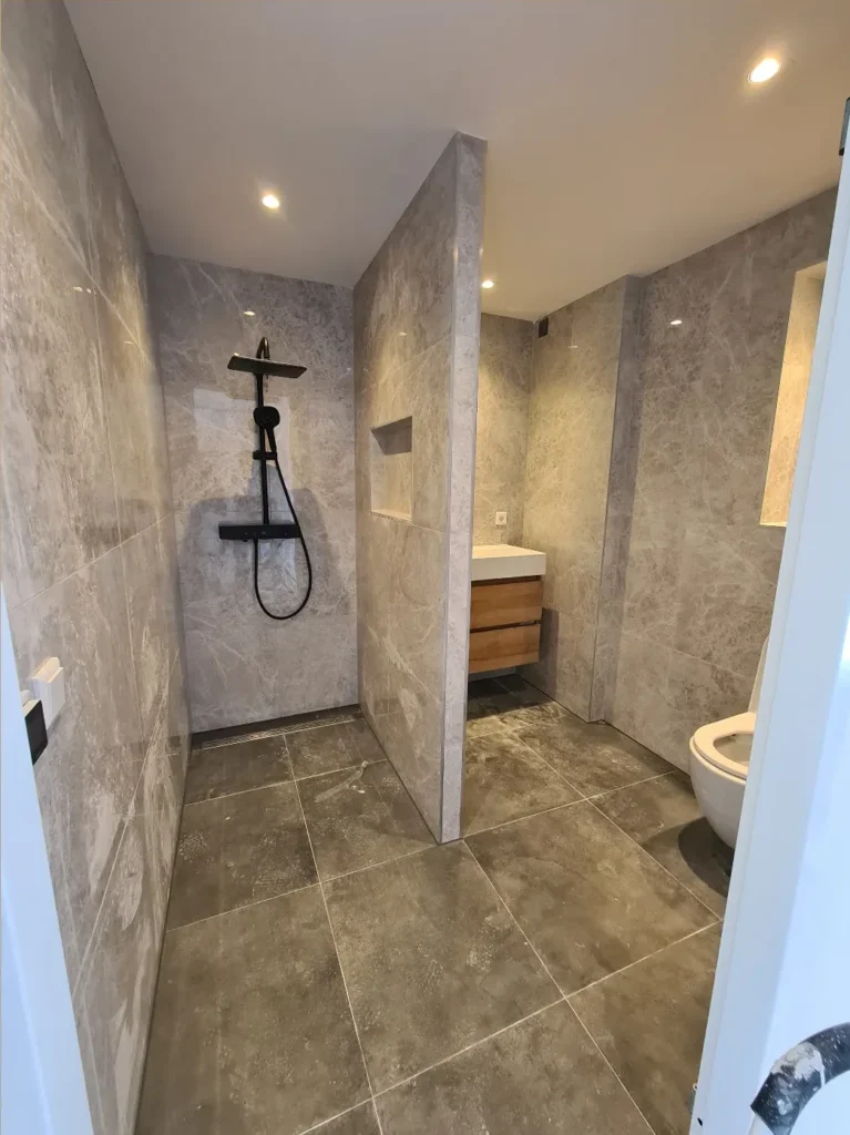 QA Renovatie: inloopdouche en toilet met grijze tegels