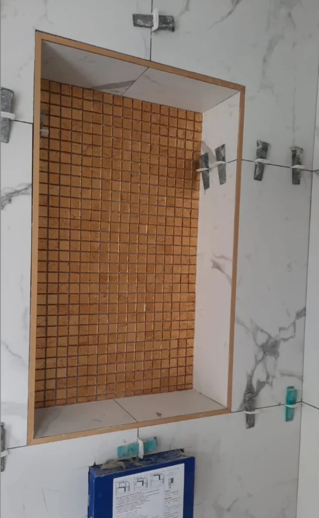 QA Renovatie: nis met mozaiek tijdens de montage